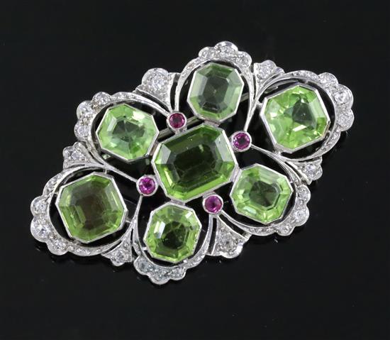 A mid 20th century pierced white gold, peridot, ruby and diamond set shaped oval brooch, gross 10.3 grams.